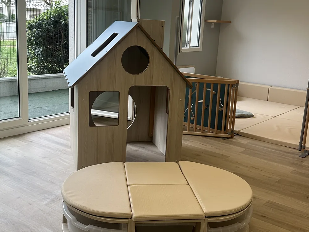 Maisonnette en bois et coussins de la crèche Rennes Colombier, ouverte sur le jardin